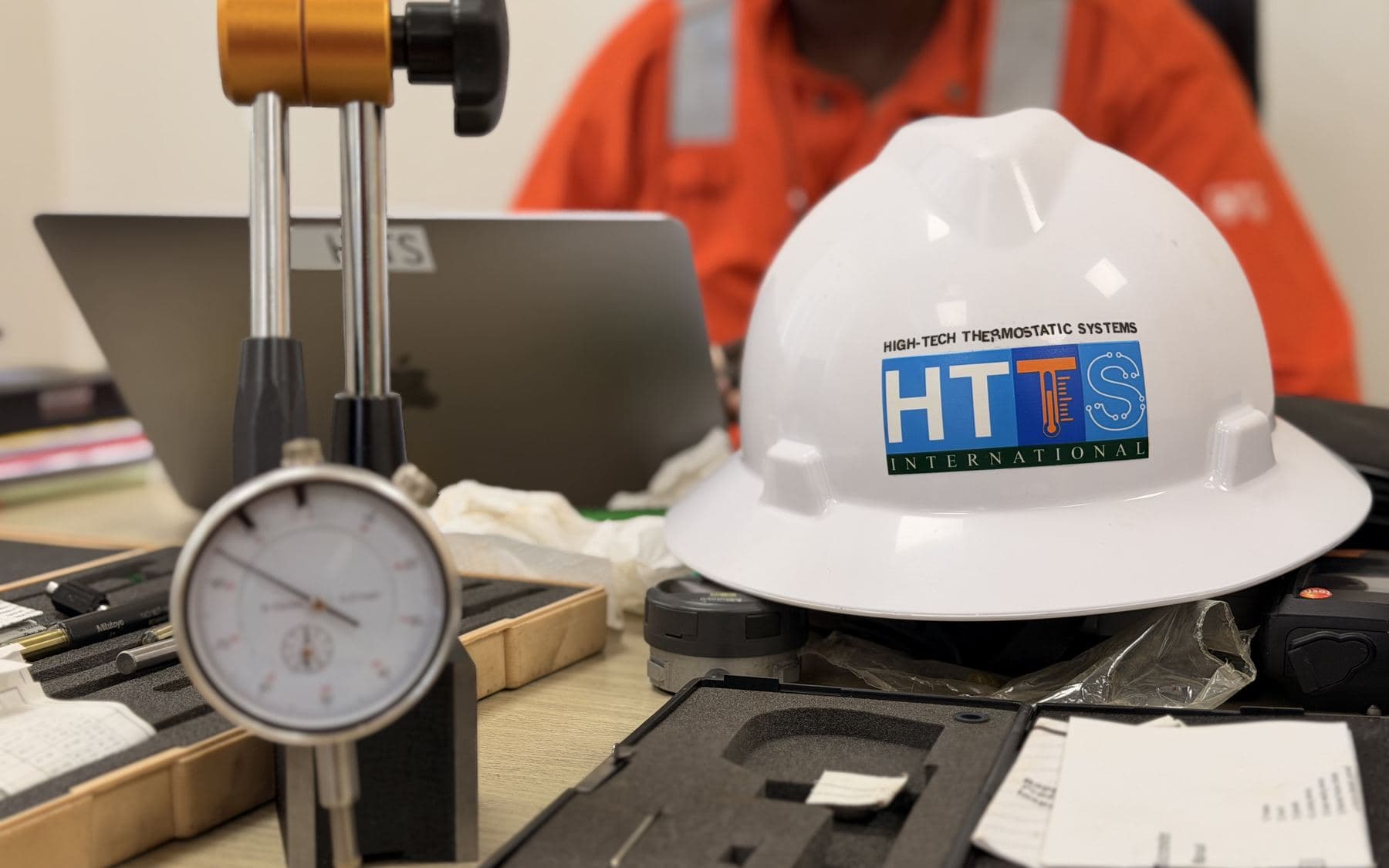 Comparateur à cadran monté sur support devant un casque HTTS, à l'atelier de métrologie